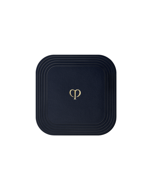 Photo of a square "PUFF (REFINING PRESSED POWDER)". It is blue-black in color, with the brand-logo engraved in gold in the center.