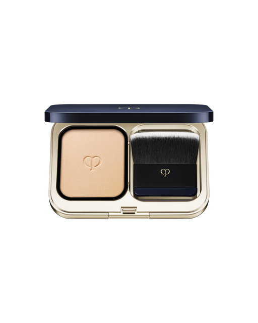 Photo of a gold compact case with powder foundation on the left and a brush on the right. SHADE: I10.