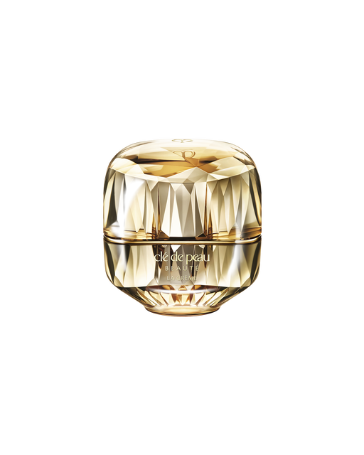 Photo of a jewel-cut, translucent gold container. The sparkling form reflects light, and the front features the brand logo and the text “LA CRÈME”.