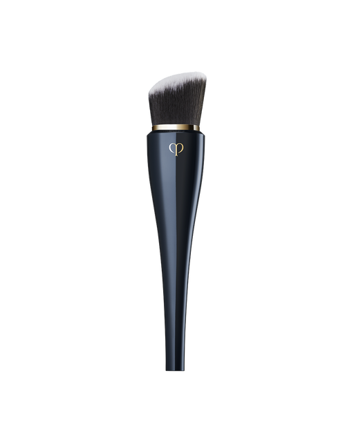 Photo of “HIGH COVERAGE FOUNDATION BRUSH” featuring a sleek, blue-black handle with a gold brand logo, and dense, slanted bristles.