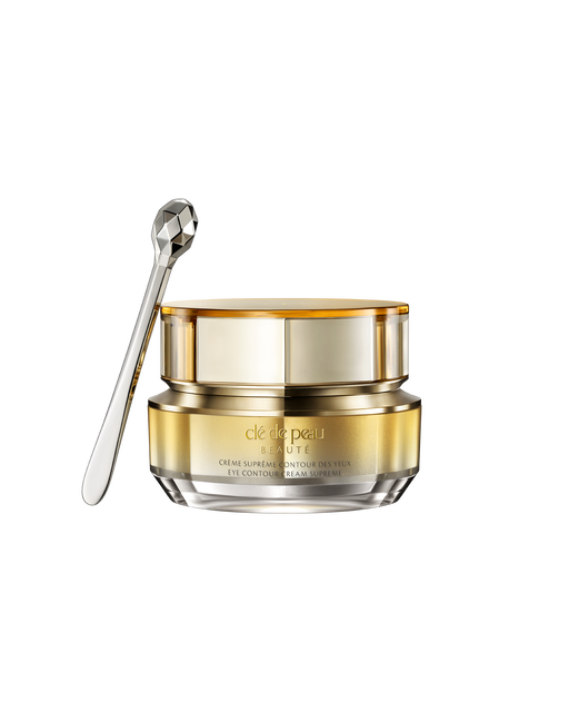 Photo of a jar of "EYE CONTOUR CREAM SUPREME" with a gold-to-silver gradient and a faceted silver spatula. SIZE: 15g