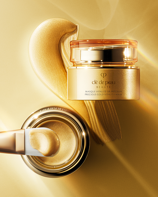 Photo of “PRECIOUS GOLD VITALITY MASK” — a visual showing the spread-out gold mask, a brush, and the jar container arranged together.