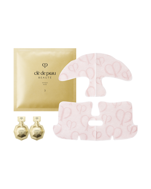 Photo of the "ILLUMINATING CONCENTRATE" set. Gold pouches labeled "1" and "2" are arranged alongside a pink sheet mask featuring the brand logo.