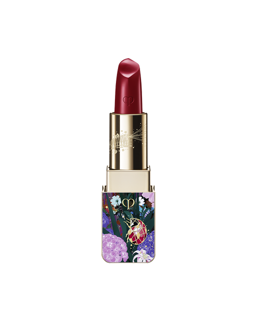 Photo of the limited-edition LIPSTICK with the stick twisted up. The tip is engraved with the brand logo, and the gold case features a special design decorated with flowers and a ladybug. SHADE: Ruby’s Spark.