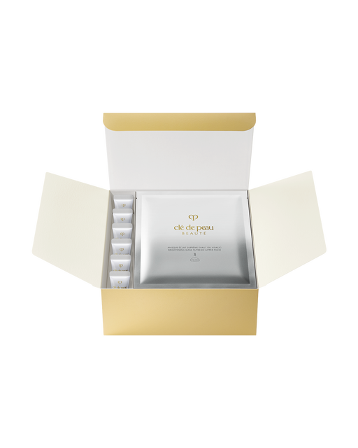 Photo of "BRIGHTENING MASK TREATMENT SUPREME," a set that includes sheet masks and pre-mask gel cleansers. The gold box contains six two-piece masks and six tubes of cleanser.