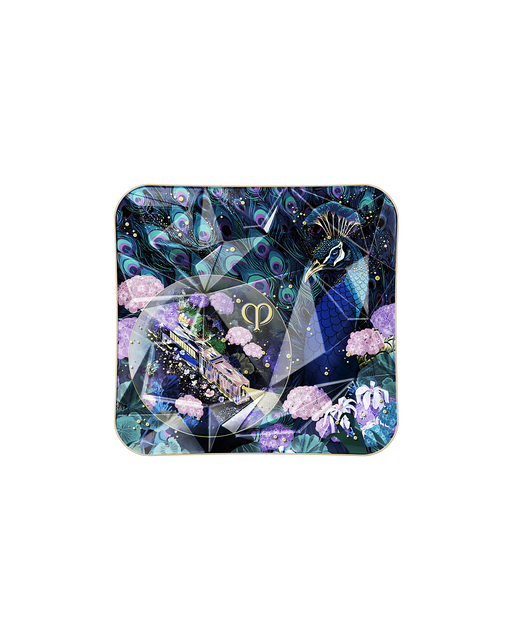 Photo of the compact case of the limited-edition THE LUMINIZING FACE ENHANCER Radiant Peafowl, featuring a special design with peacocks and floral patterns.