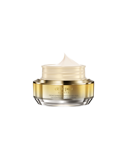 Photo of "EYE CONTOUR CREAM SUPREME" with its lid open, revealing a fluffy, smooth cream inside a gold-and-silver jar.