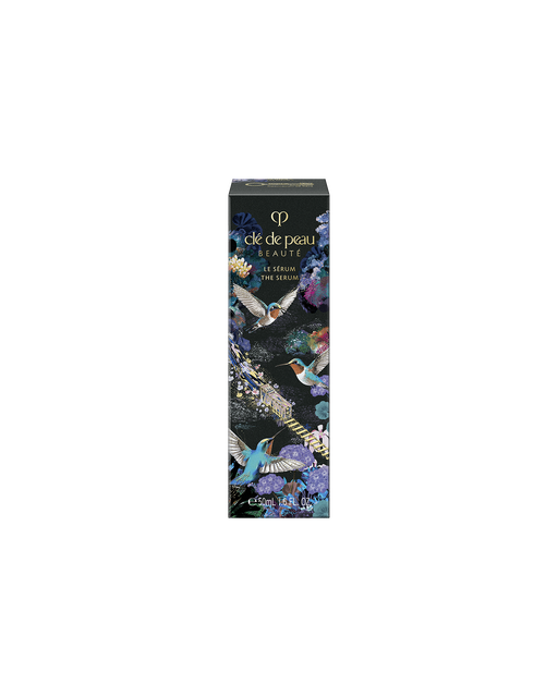 Photo of the outer box of the limited-edition THE SERUM in a 50ml size. The blue-black package features an elaborate design with a gold train, blue birds, and colorful flowers across the surface.