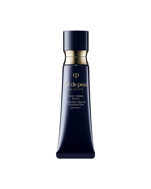 Photo of a blue black tube of "RADIANT CREAM FOUNDATION"adorned with a golden ring. SHADE: O20