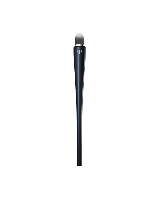 Photo of “CONCEALER BRUSH” featuring a sleek, blue-black handle with a gold brand logo, and a compact, rounded tip.