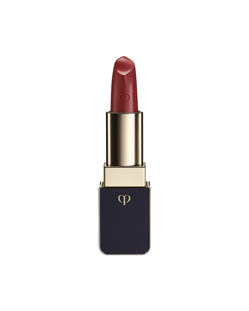 Photo of "LIPSTICK MATTE" with the stick twisted up. The tip is engraved with the brand logo, and the body features a combination of blue-black and gold sides. SHADE: Orange Cosmos.
