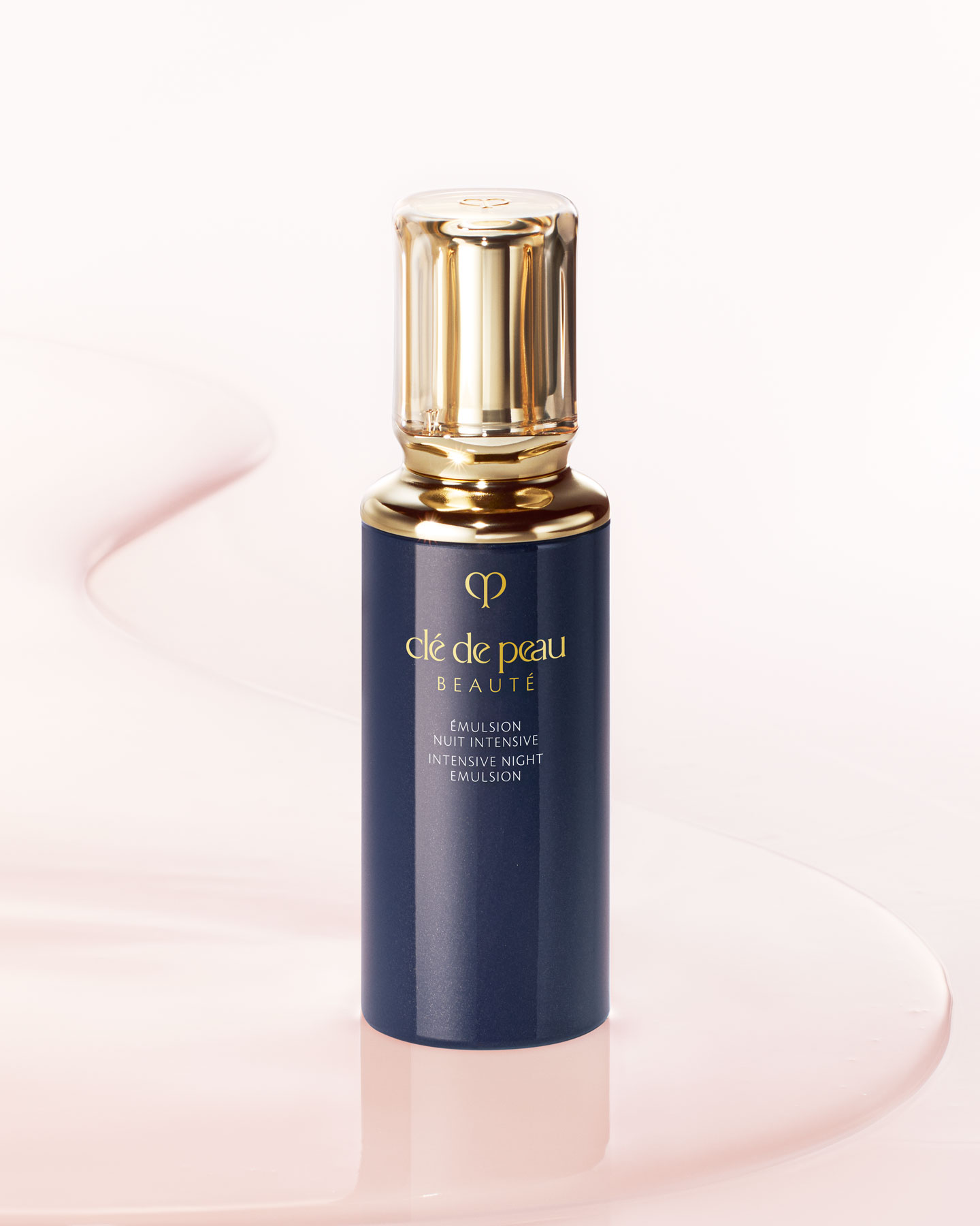 Photo of a dark blue INTENSIVE NIGHT EMULSION bottle with a rounded, translucent gold cap.