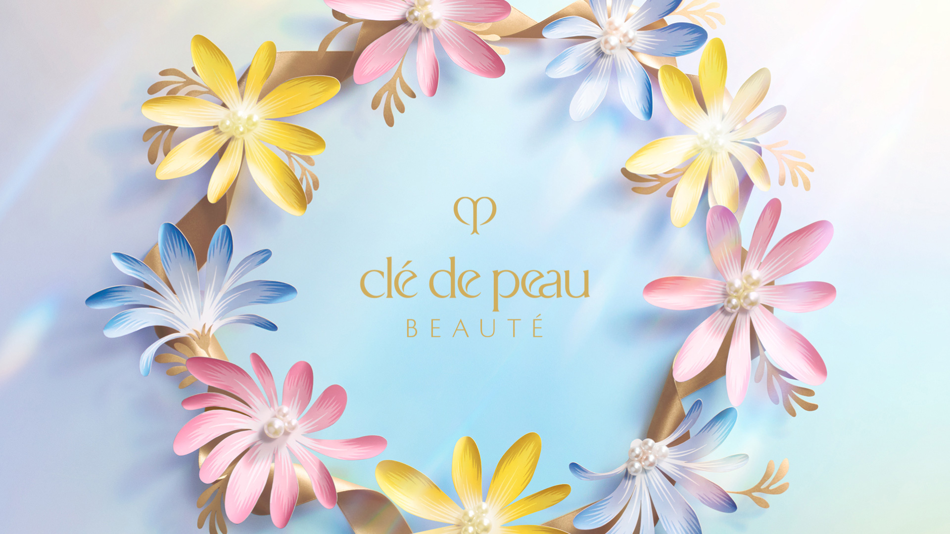 Wallpaper of the Clé de Peau Beauté logo at the center of a circular arrangement of colorful flowers.