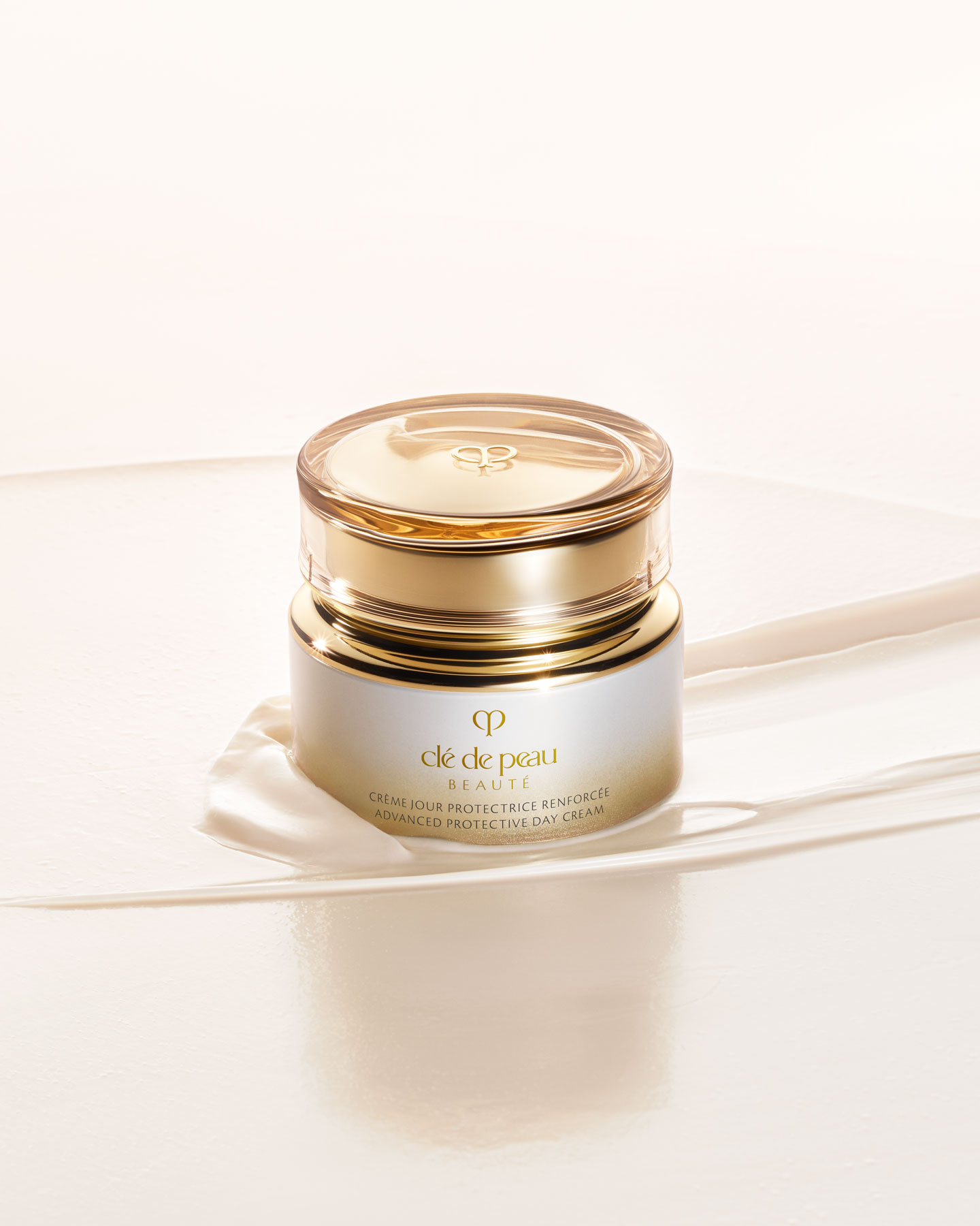 Photo of a ADVANCED PROTECTIVE DAY CREAM jar with a rounded, translucent gold lid. The jar has a gradient design from white at the top to gold at the bottom.