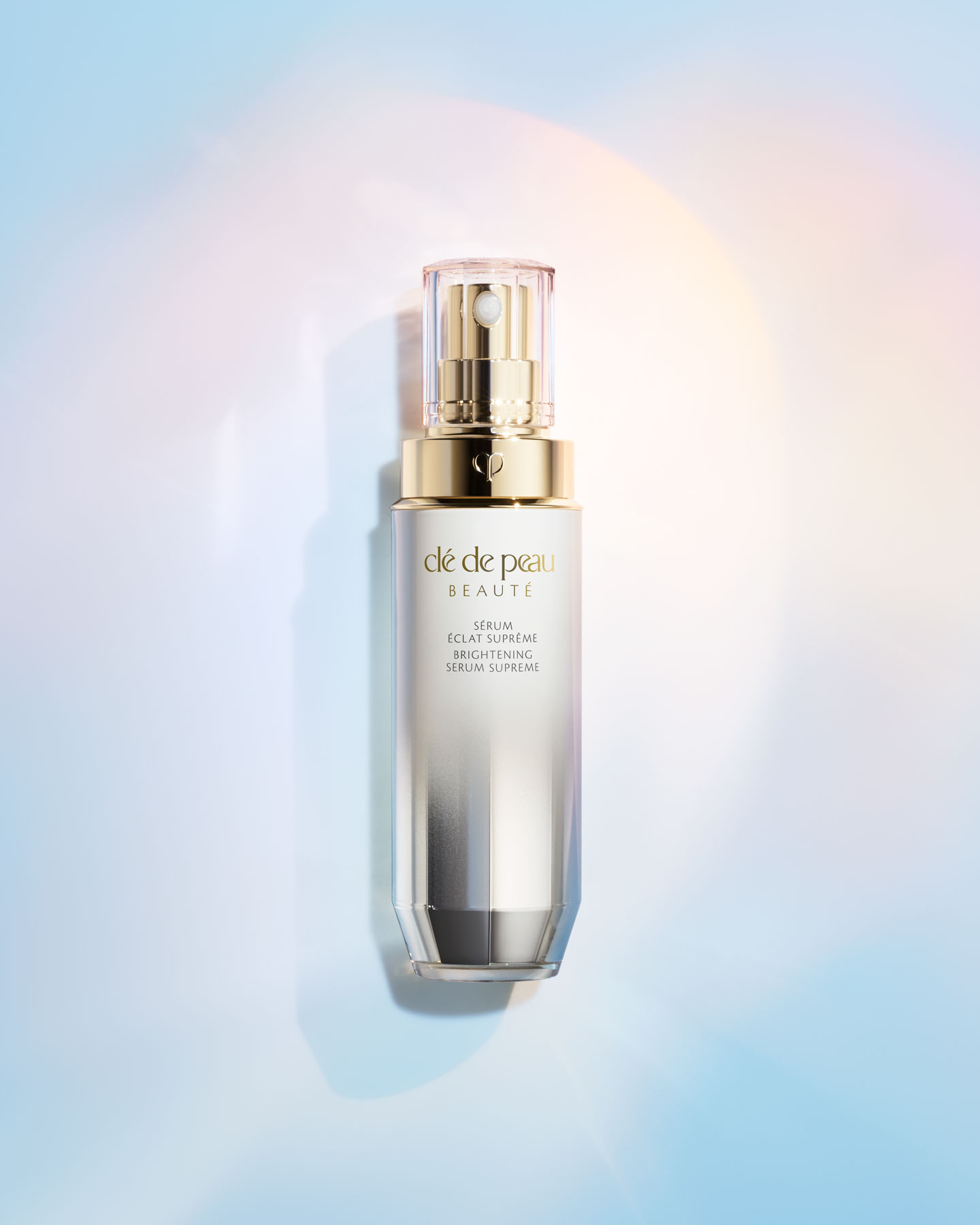 Photo of a BRIGHTENING SERUM SUPREME bottle with a tall, cylindrical shape and a white-to-silver gradient finish.