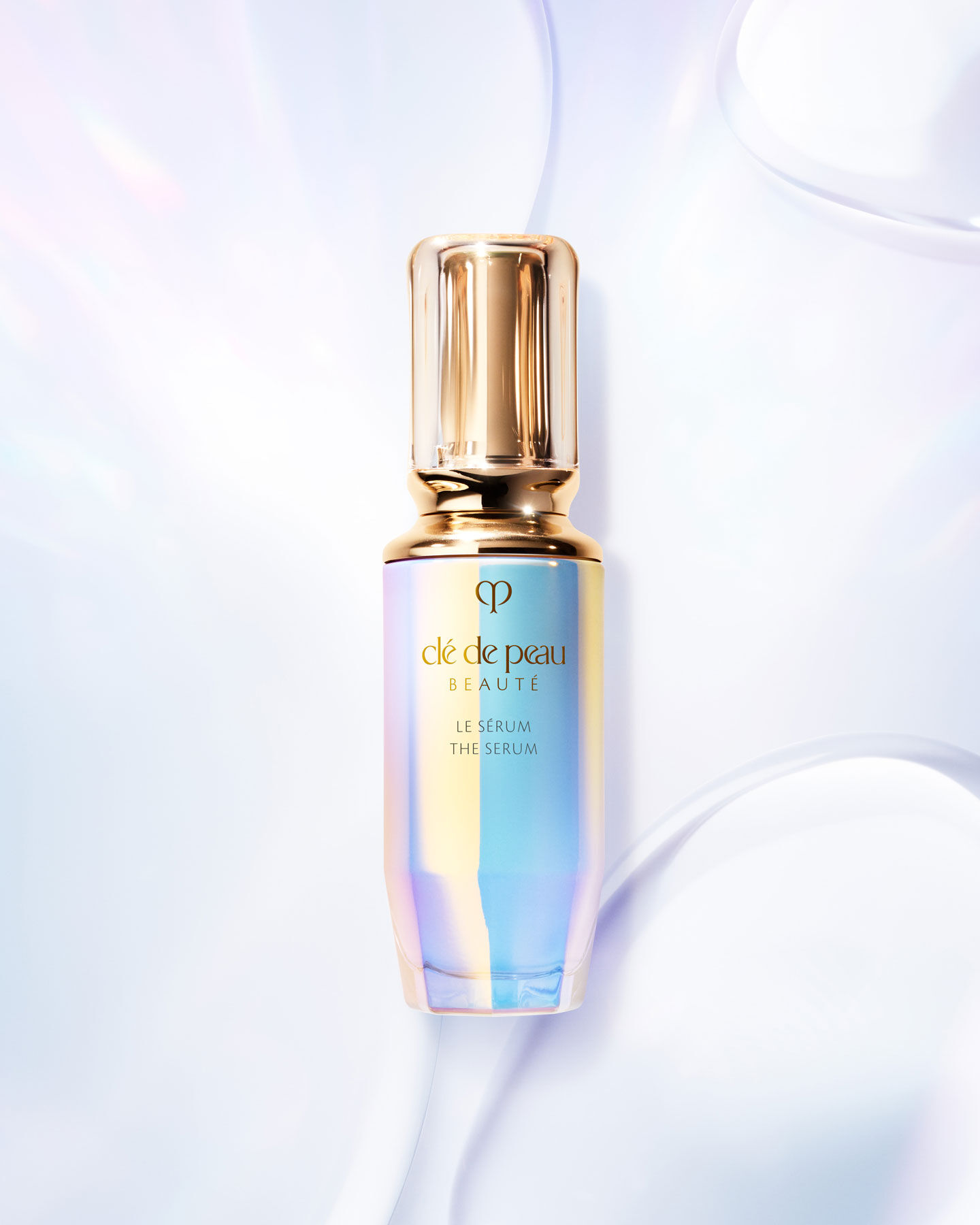 Photo of The Serum bottle with an iridescent finish and a rounded, translucent gold cap.