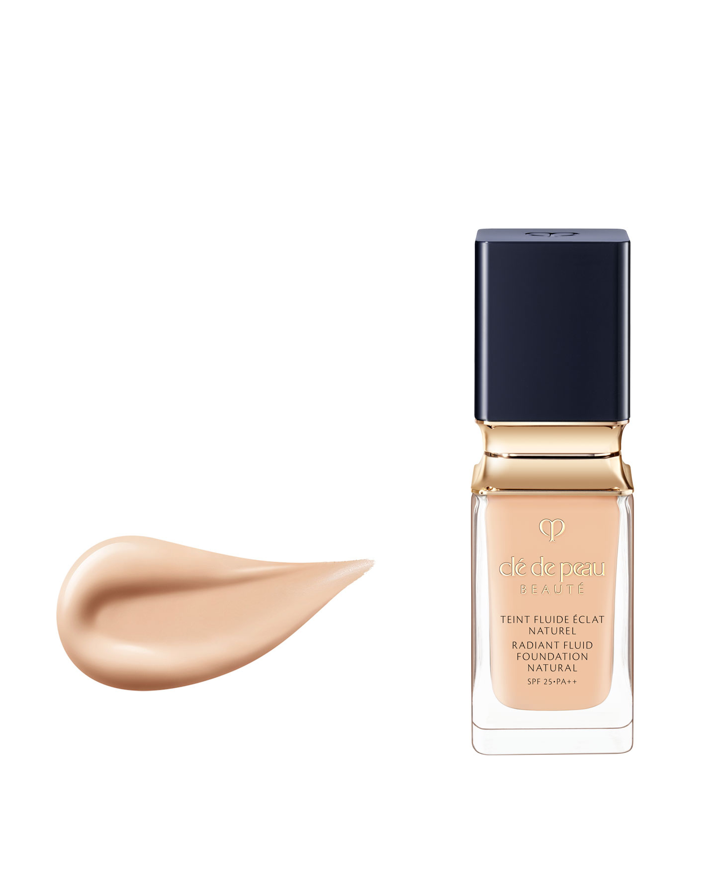 Photo of a RADIANT FLUID FOUNDATION NATURAL bottle with gold accents and a blue-black cap, alongside a smooth, dewy beige texture.