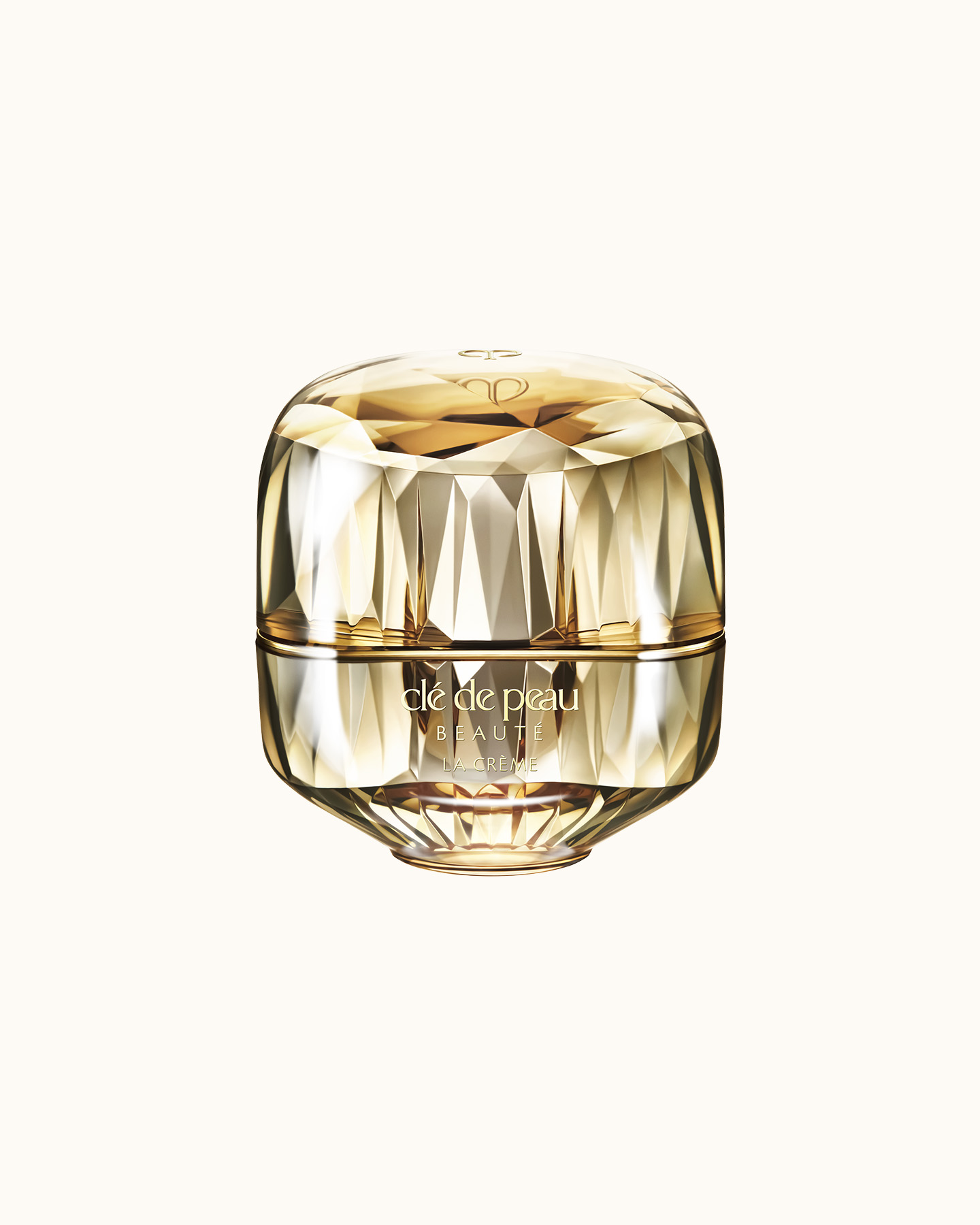 Photo of a jewel-cut, translucent gold container. The sparkling form reflects light, and the front features the brand logo and the text “LA CRÈME” (current packaging).