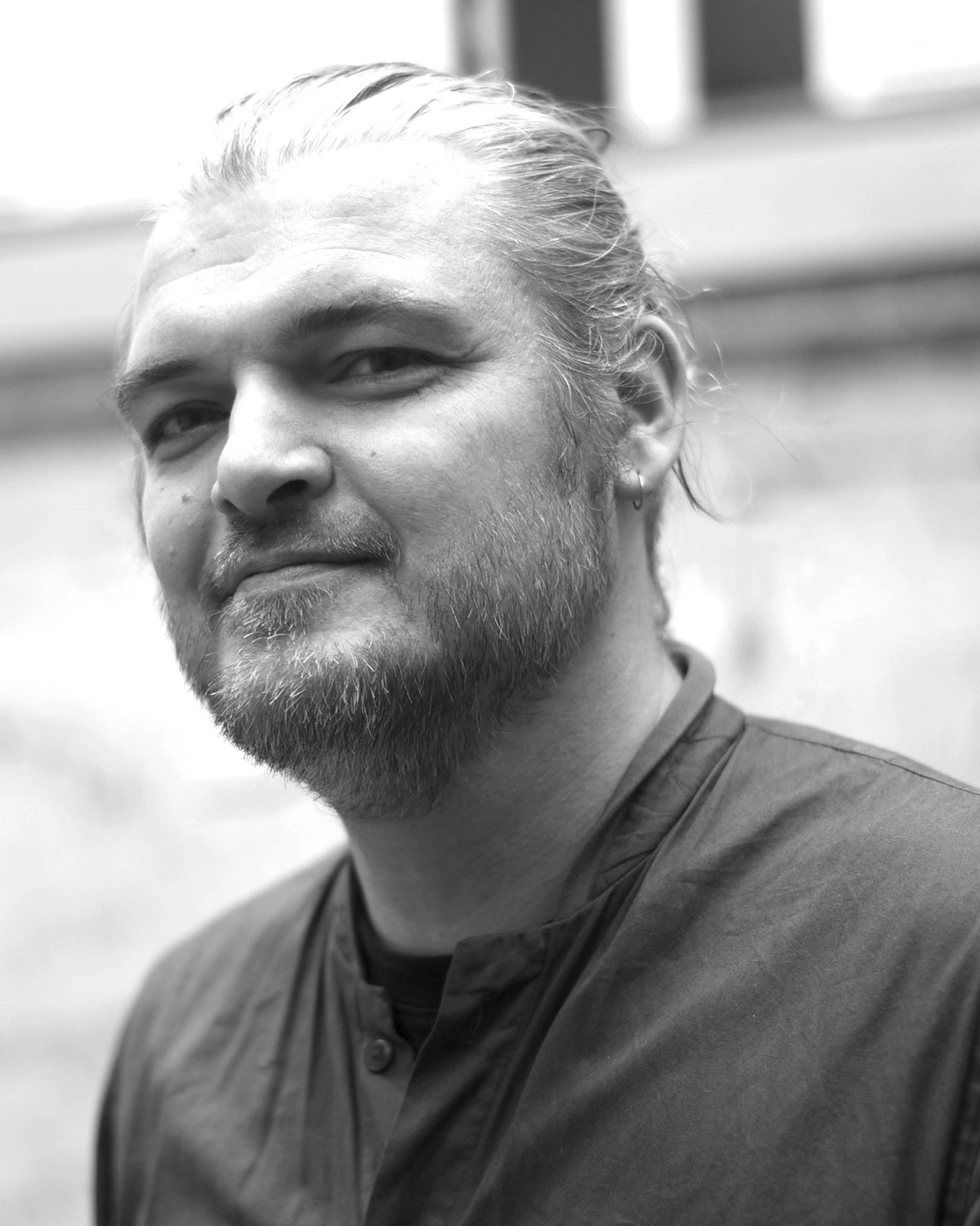 Photo of artist Stéphane Kiehl in black and white, looking at the camera with a slight smile.