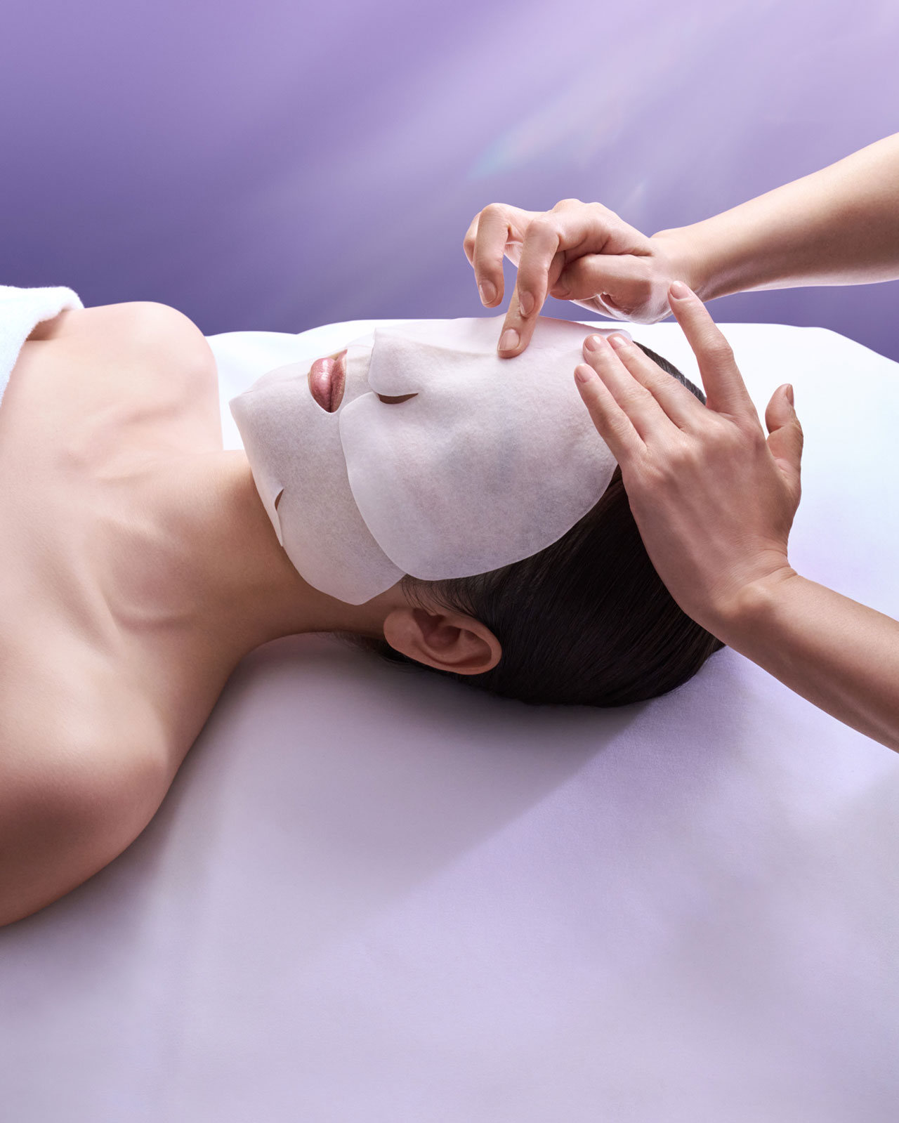 Photo of a woman receiving a facial massage using a rich cream mask.