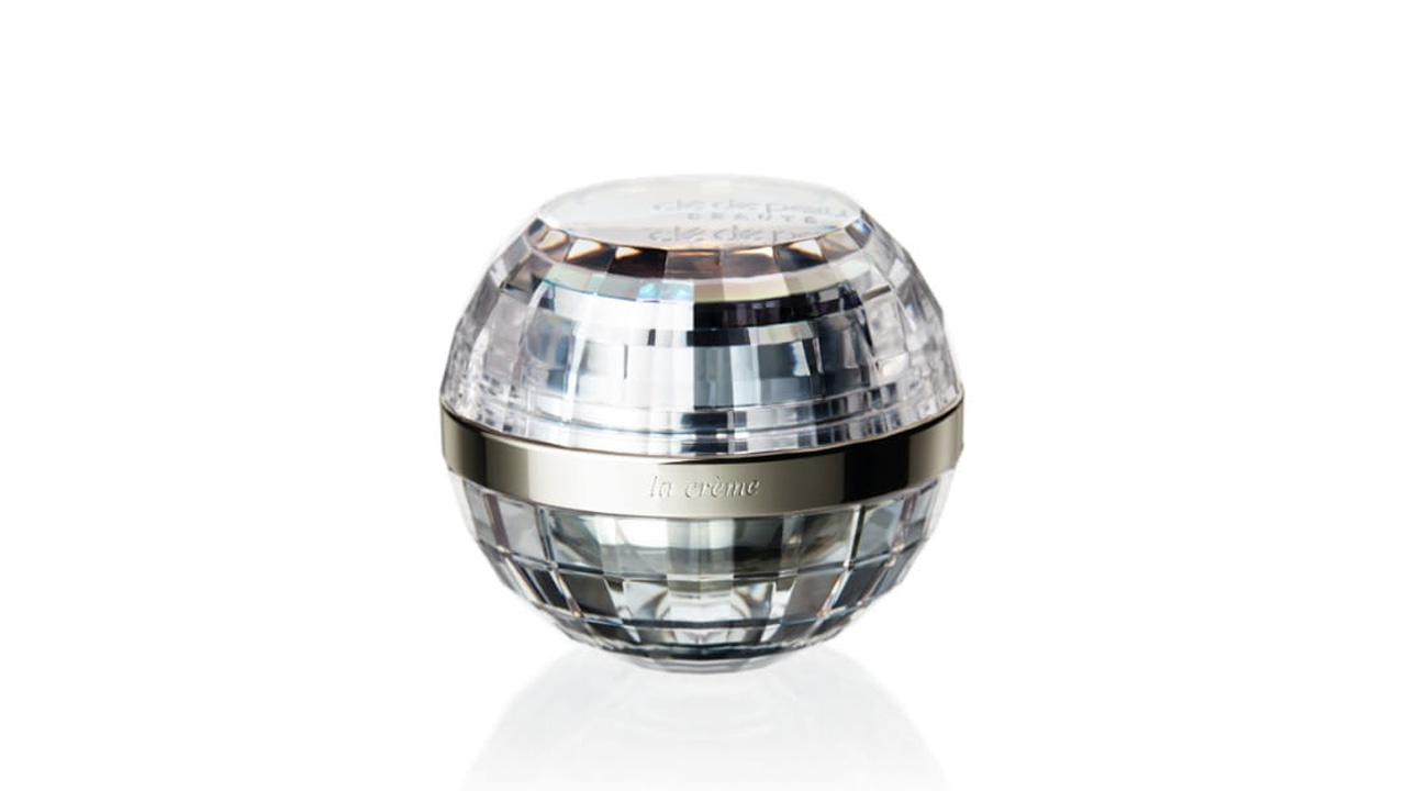 Photo of a spherical design with mirrorball-like cuts. A silver band around the center is engraved with the text “la crème” (former packaging).