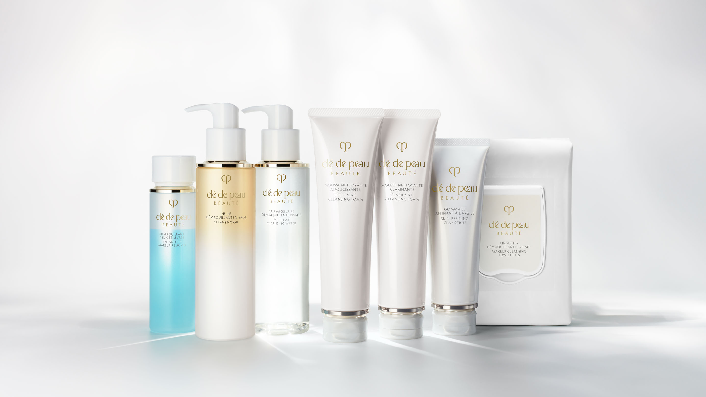 Photo of all seven products in the Clé de Peau Beauté cleansing collection, including various makeup removers, facial cleansing foams, a scrub, and towelettes.