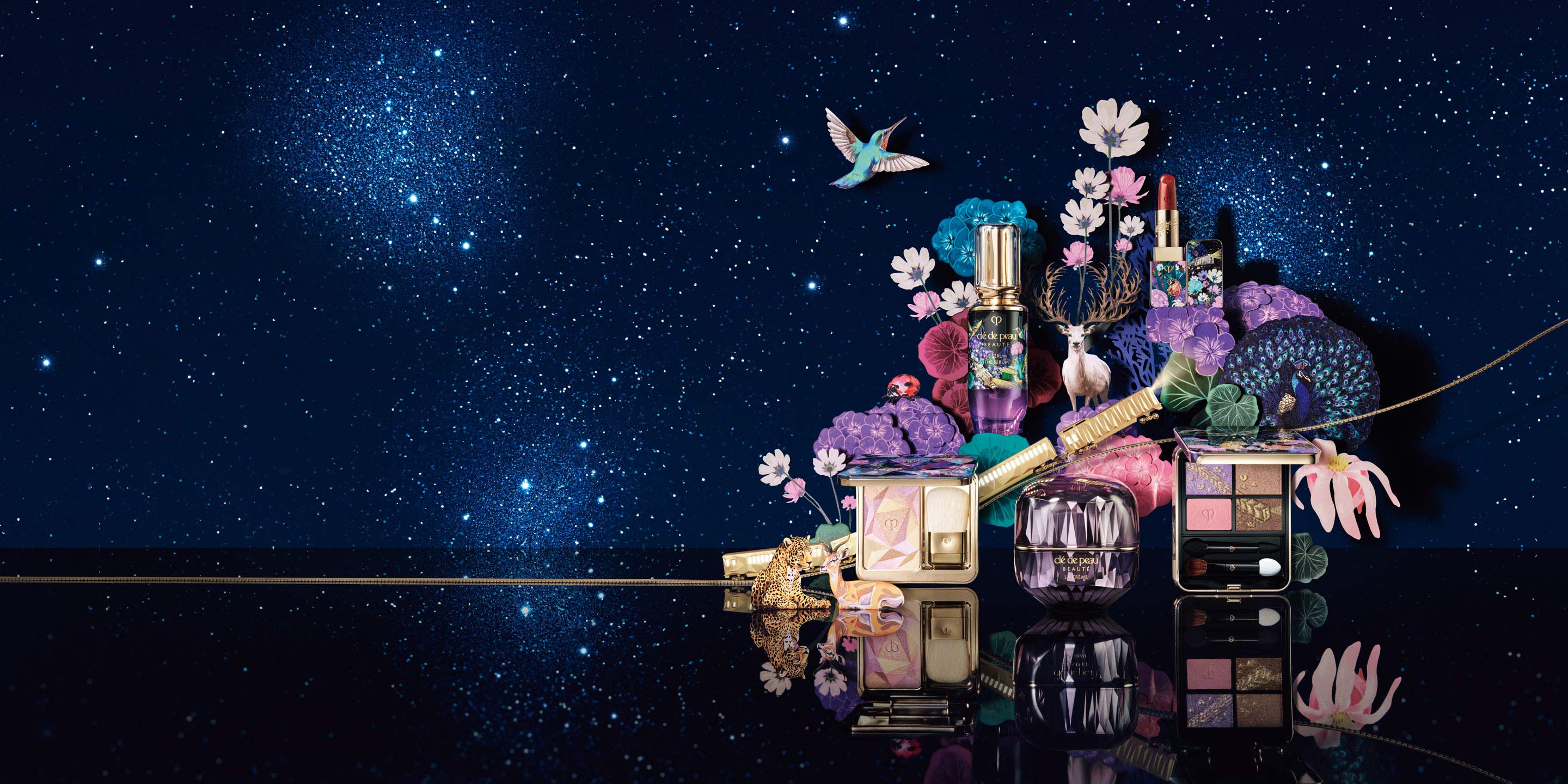 Photo of limited-edition products from the HOLIDAY 2025 collection, arranged under a starry night sky, surrounded by illustrated animals such as a white deer, a peacock, and a leopard, along with colorful flowers.