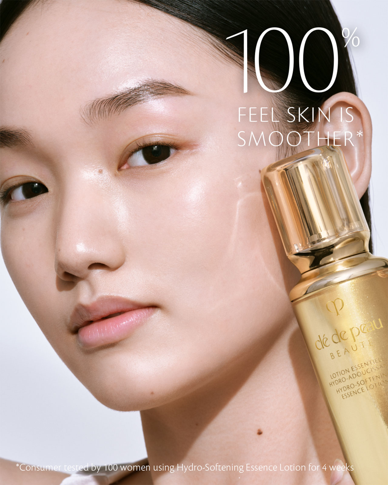 Photo of a woman applying HYDRO-SOFTENING ESSENCE LOTION to her cheek.