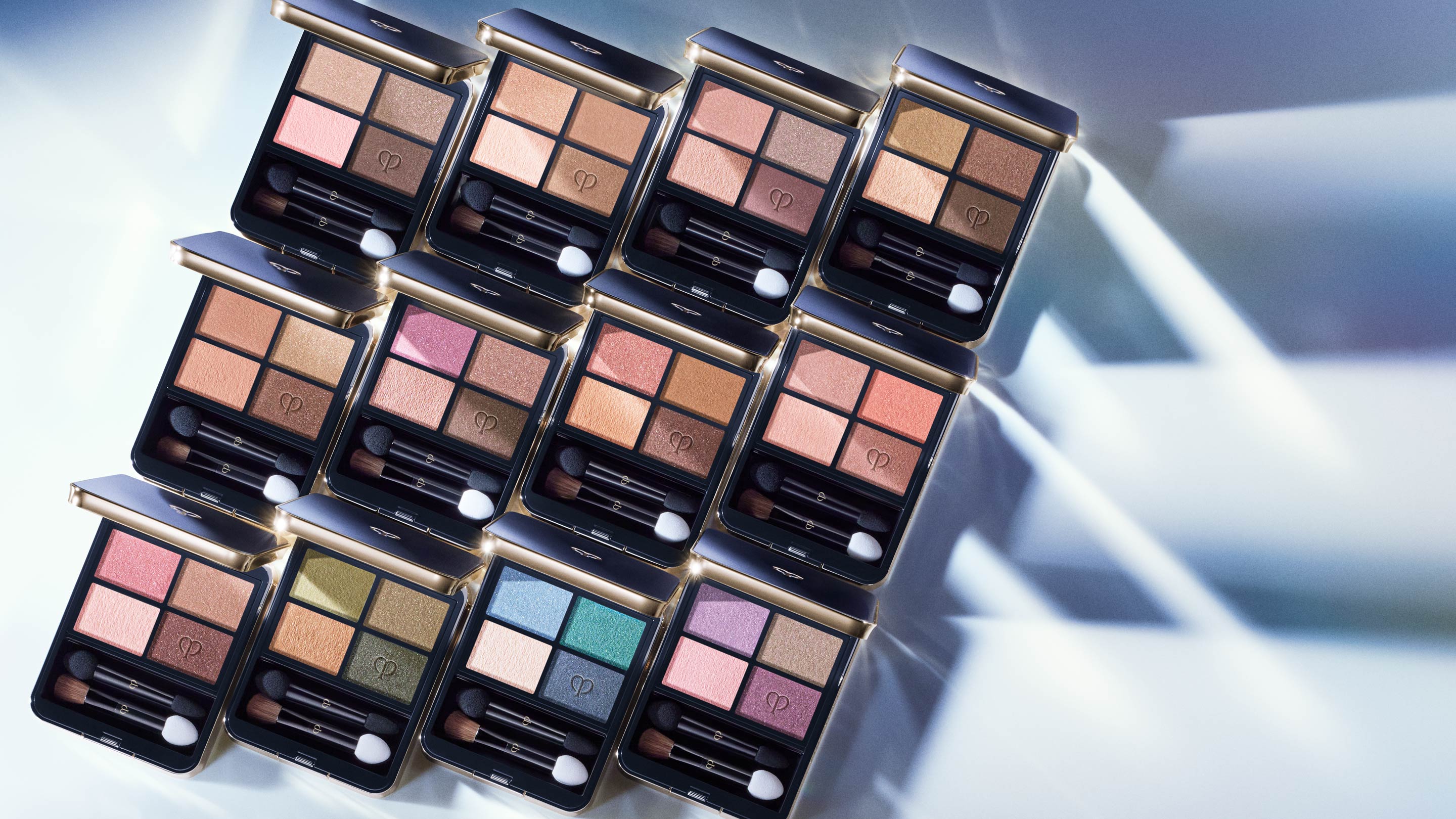 Photo of twelve open Eye Color Quad palettes.