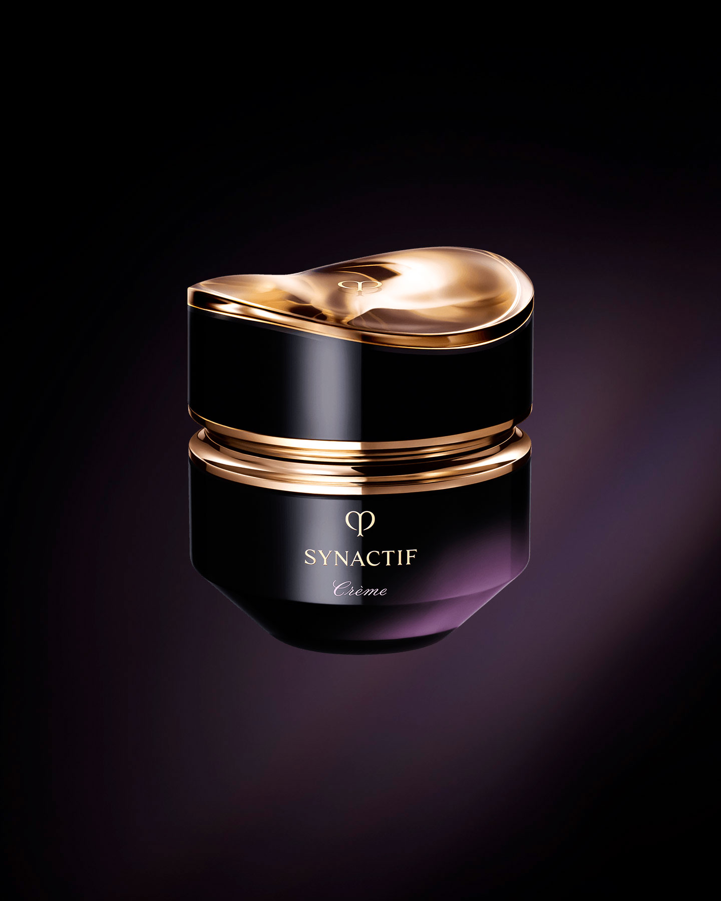 Photo of the Clé de Peau Beauté Synactif CREAM. The cream is presented in a jar with a black-to-purple gradient. The lid features a sculptural gold design, and the 'SYNACTIF' logo is elegantly displayed on the front.