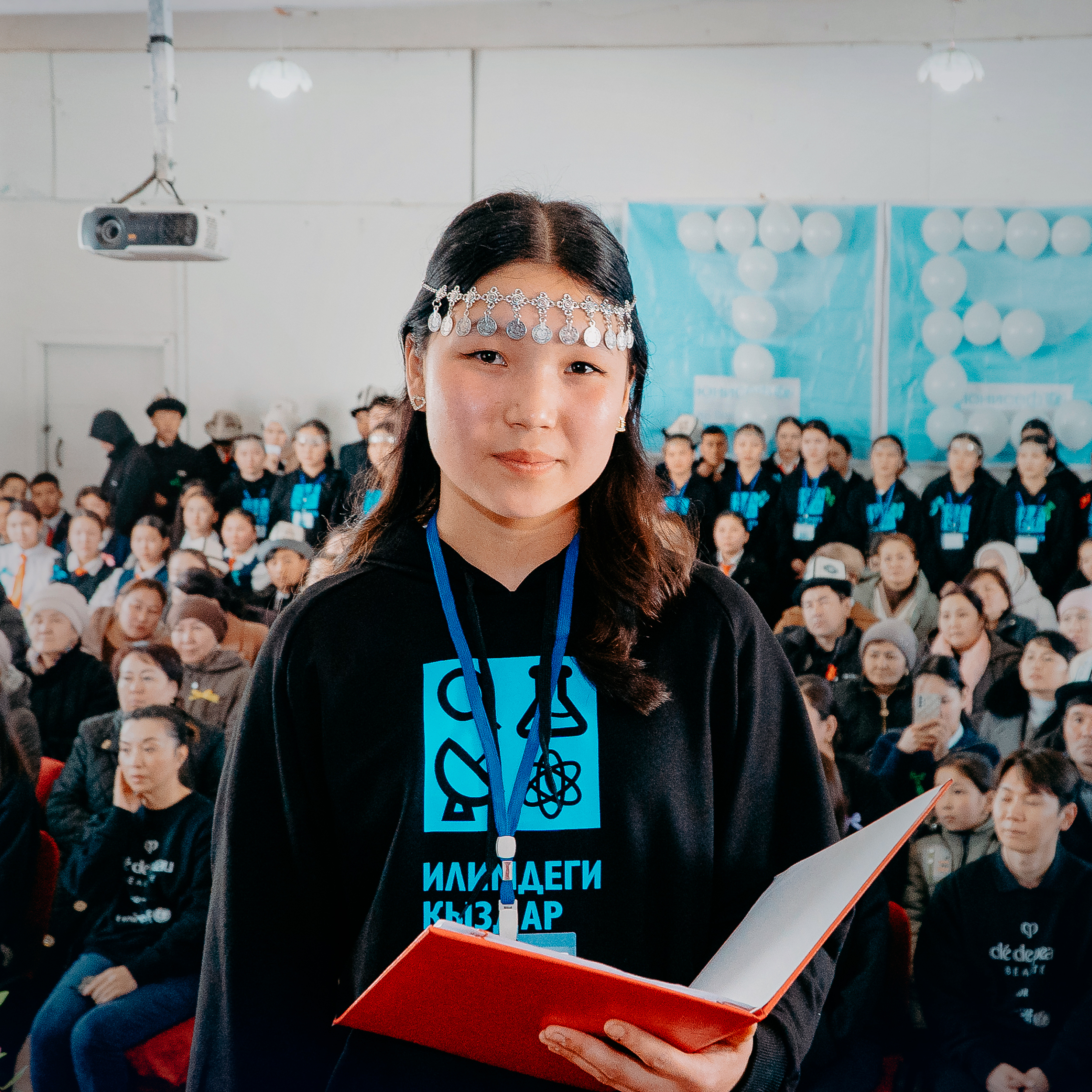 Photo of a girl holding a red notebook in Kyrgyzstan, taken during Clé de Peau Beauté’s 2025 UNICEF partnership visit.